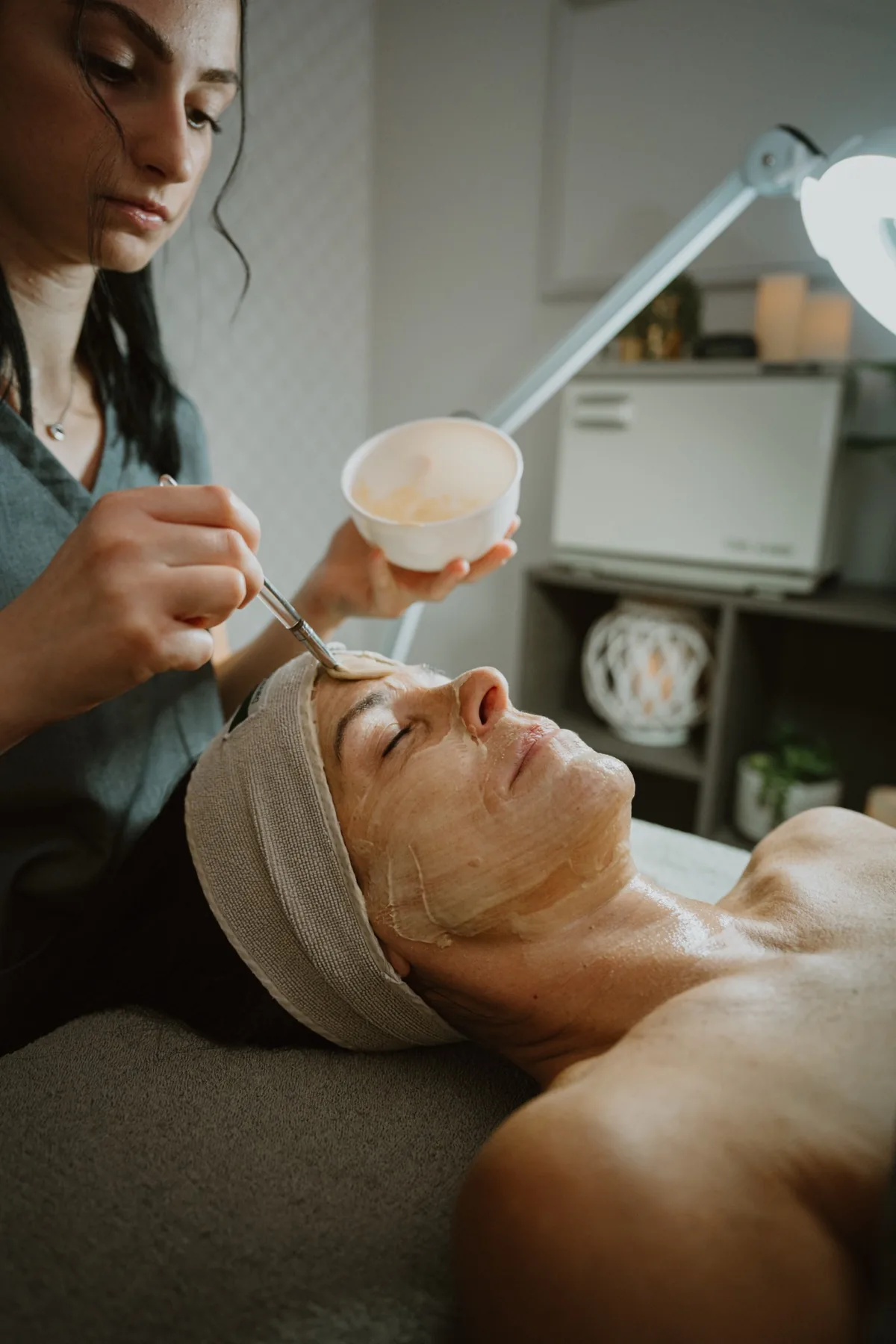 Esthetician applying a mask during a Signature Glow Facial